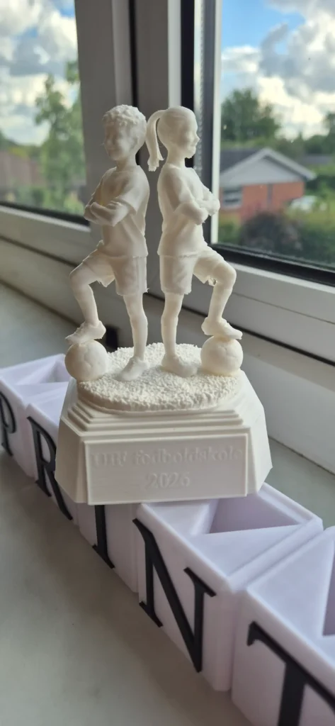 Fodboldtrofæ pige og dreng ryg mod ryg